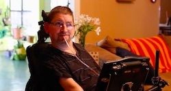 Dave Chapple in wheelchair using a sip and puff assistive technology device