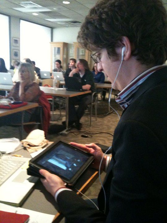 Christopher Schmitt watching a Summit event on an iPad